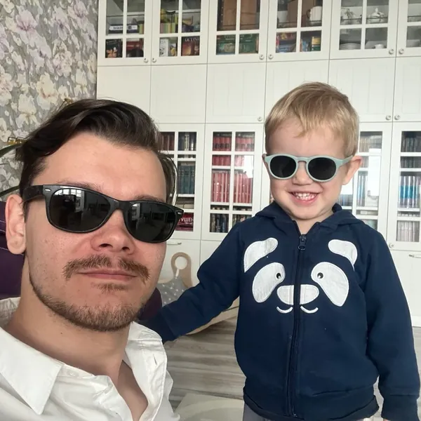 Tim and Timofey at home, both in sunglasses.
